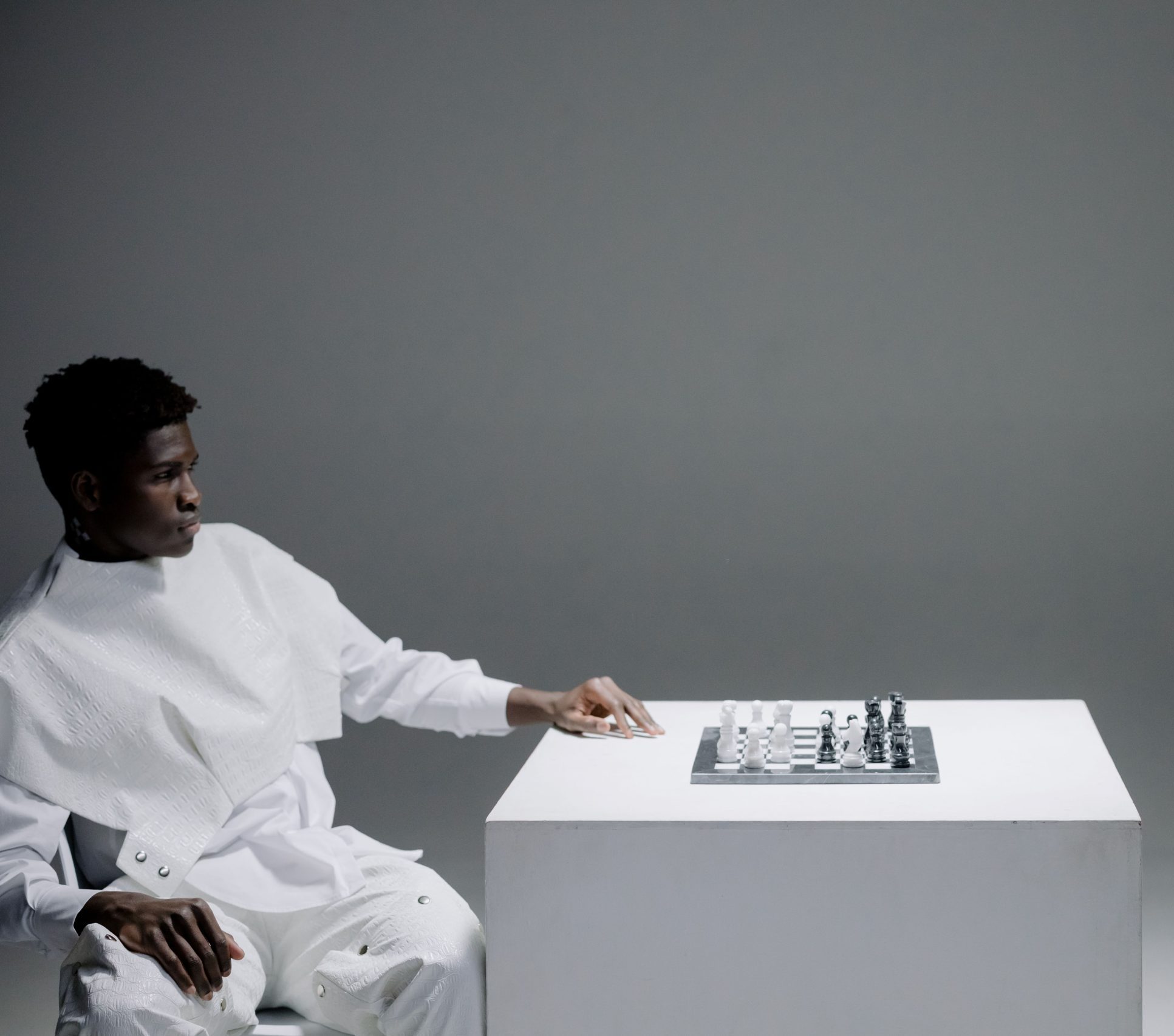 Personne assise devant un échiquier face à un buste, image symbolisant la stratégie, la réflexion et la place de l’humain face à une intelligence capable d’analyser.